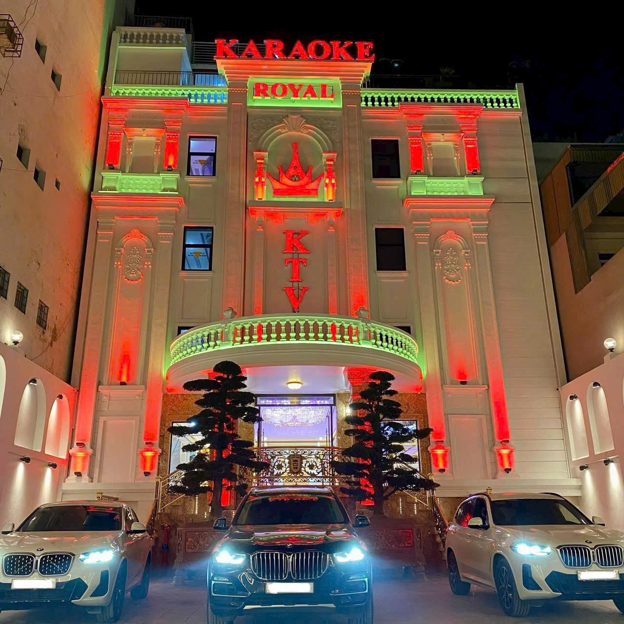 Karaoke Royal 97 Hà Nội - Mặt tiền tòa nhà về đêm với đèn đỏ và xanh rực rỡ